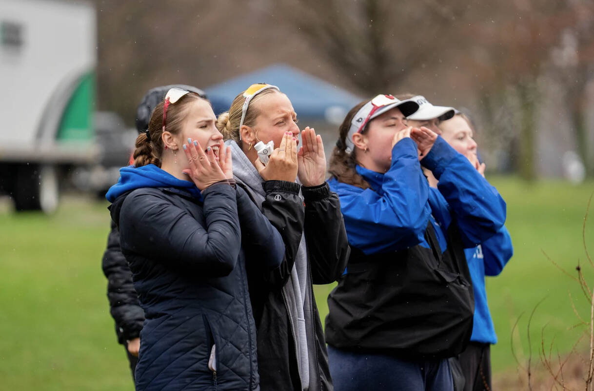 Rowers cheer on teammates during a race